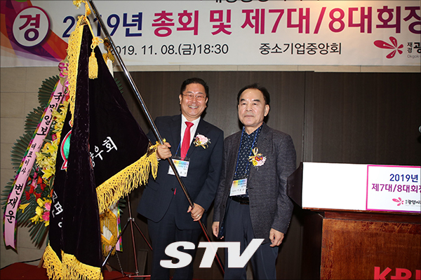 김호승 신임회장이 이돈선 직전회장에 향우회 기를 전달후 기념사진©재경 옥곡면 향우회 제공
