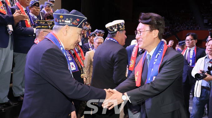 김민석 국무총리가 24일 서울 송파구 올림픽공원 올림픽홀에서 열린 제73주년 재향군인의 날 기념식에서 참석자들과 기념 촬영 후 악수하고 있다.